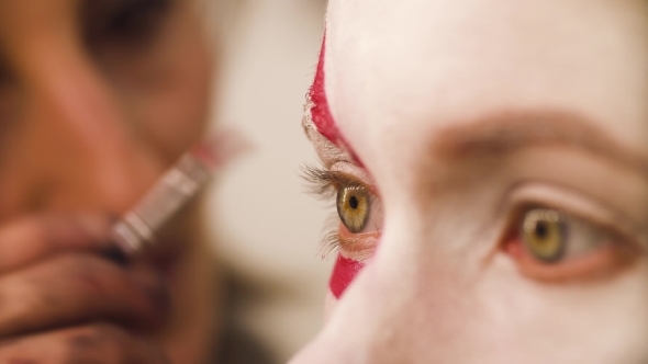 590x332 Makeup Artist Drawing Red Lines On The Face - Makeup Art Drawing