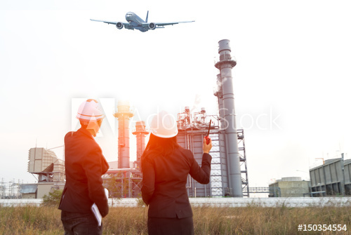 500x335 engineer wearing white helmet holding paper drawing with oil - Refinery Drawing