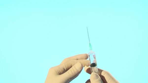 600x338 doctor with syringe drawing up clear liquid form bottle - Syringe Drawing