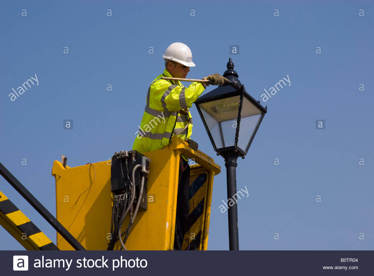 1300x960 Man Painting Lamp Post Using Cherry Picker In The Uk Stock Photo - Lamp Post Painting