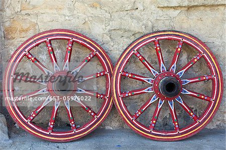450x299 Two Decoratively Painted Wagon Wheels Leaning Against A Wall - Wagon Wheel Painting