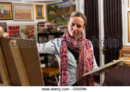 450x320 Female Artist Standing And Painting With Oils - Woman Artist Painting