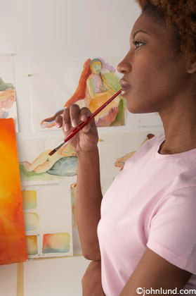 279x420 Woman Artist Contemplating Her Work With Paintbrush Against Her Lips - Woman Artist Painting