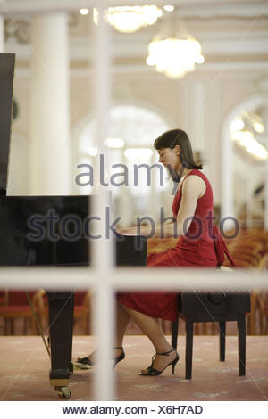 300x470 Woman In Red Dress Plays The Piano Stock Photo 144282988 - Woman In Red Dress Playing Piano Painting